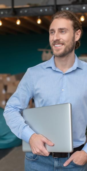 smiling-and-conident-man-holding-his-computer-2024-10-18-05-40-13-utc.jpg